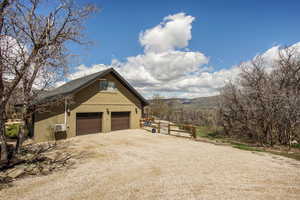 View of property exterior with a mountain view and a garage