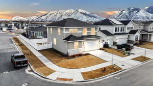 View of front facade featuring a residential view, a mountain view, concrete driveway, and stucco siding