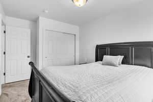 Bedroom with light carpet and a closet