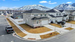 View of front of property with driveway, a residential view, an attached garage, a mountain view, and stucco siding