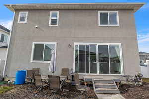 Rear view of house featuring fence and stucco siding