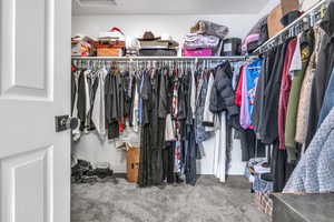 Spacious closet with attic access and carpet flooring