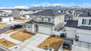 View of front facade with stone siding, a residential view, a mountain view, and concrete driveway