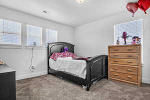 Bedroom with carpet floors, visible vents, and baseboards