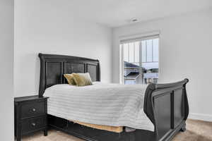 Bedroom featuring baseboards, visible vents, and light colored carpet