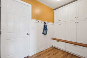 Mudroom featuring a wainscoted wall and light wood-type flooring