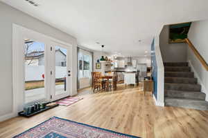 Foyer featuring light wood finished floors, stairway, visible vents, and baseboards