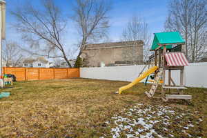 View of yard featuring a playground and a fenced backyard