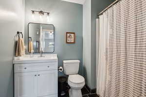 Full bathroom with toilet, curtained shower, tile patterned flooring, and vanity