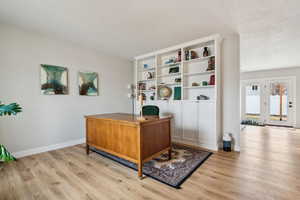 Office space with baseboards and light wood-style floors