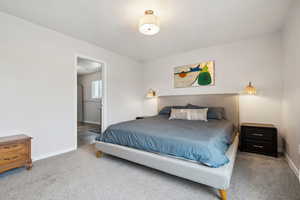 Carpeted bedroom featuring baseboards and connected bathroom