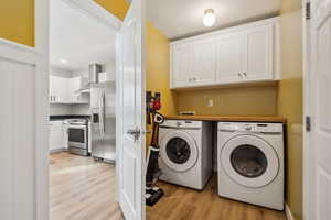 Laundry room featuring laundry area, light wood-style flooring, and washer and dryer