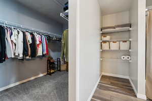 Walk in closet with wood finished floors