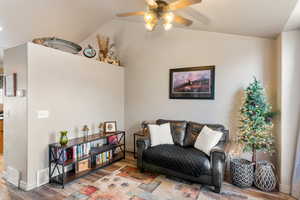 Sitting room featuring vaulted ceiling, wood finished floors, visible vents, and a ceiling fan