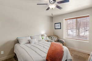 Master bedroom featuring a ceiling fan, a textured ceiling, baseboards, and carpet flooring