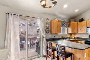 Kitchen with dark countertops, plenty of natural light, stainless steel microwave, and a sink