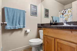 Full bathroom with toilet, tile patterned floors, baseboards, and vanity