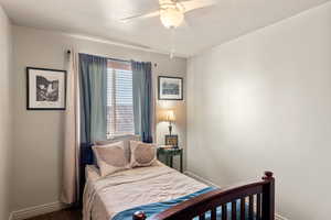 Carpeted bedroom with ceiling fan and baseboards