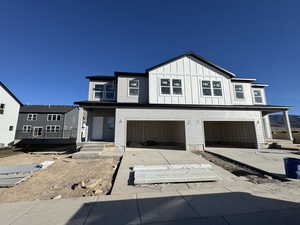 View of front of house featuring an attached garage, board and batten siding, and concrete driveway