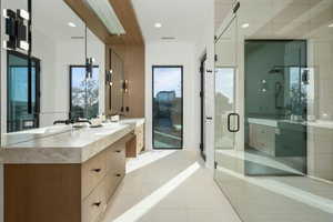 Bathroom featuring double vanity, a stall shower, visible vents, tile patterned flooring, and a sink