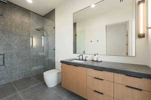 Full bath with toilet, a stall shower, tile patterned flooring, and vanity