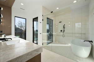 Bathroom with double vanity, a soaking tub, tile patterned flooring, a shower stall, and a sink