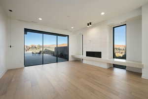 Unfurnished living room featuring light wood finished floors, a fireplace, and recessed lighting