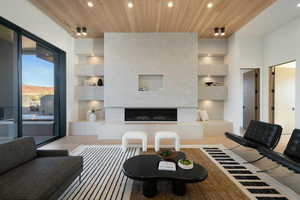 Living room with built in features, a high end fireplace, wood ceiling, light wood-style flooring, and recessed lighting