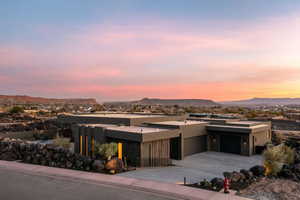 View of front of home with a mountain view, driveway, an attached garage, and stucco siding