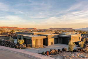 View of front of property with a garage, concrete driveway, a mountain view, and stucco siding