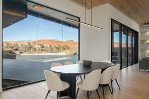 Dining room with wood ceiling, a mountain view, and light wood-style flooring