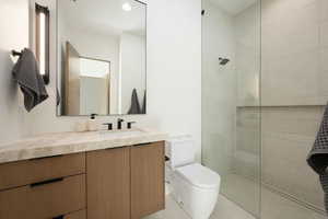 Full bathroom featuring toilet, tile patterned floors, walk in shower, and vanity