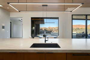 Kitchen featuring light countertops, a mountain view, a sink, and modern cabinets