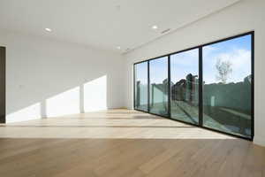 Unfurnished room featuring visible vents, light wood-style flooring, and recessed lighting