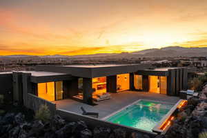 Rear view of property with a patio area, a mountain view, and an outdoor pool