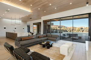 Living room featuring a mountain view, recessed lighting, wood ceiling, visible vents, and light wood-style floors