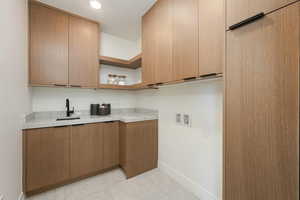 Kitchen featuring open shelves, light countertops, a sink, modern cabinets, and baseboards