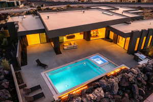 View of pool with a patio and an in ground hot tub