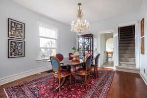 Dining room featuring visible vents, arched walkways, baseboards, stairway, and wood finished floors