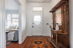 Foyer entrance featuring dark wood-style floors and baseboards