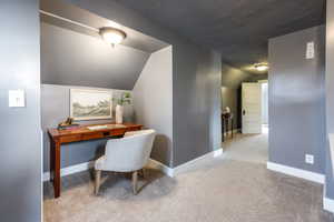 Office with lofted ceiling, a textured ceiling, light carpet, and baseboards