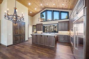 Kitchen with wooden ceiling, dark brown cabinetry, appliances with stainless steel finishes, a center island, and pendant lighting