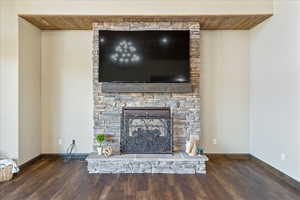 Interior details with a fireplace, baseboards, and wood finished floors