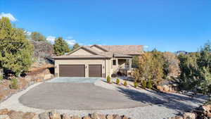 Ranch-style house featuring an attached garage, concrete driveway, and stucco siding