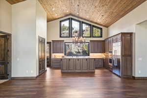 Bar with a chandelier, built in fridge, wood ceiling, and decorative light fixtures