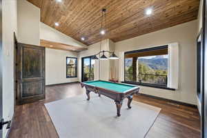 Recreation room with high vaulted ceiling, pool table, dark wood-type flooring, wood ceiling, and baseboards