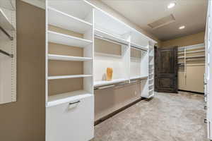 Spacious closet featuring attic access and light colored carpet