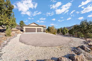 View of front of house featuring driveway, an attached garage, a mountain view, and stucco siding