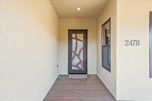 Doorway to property featuring stucco siding