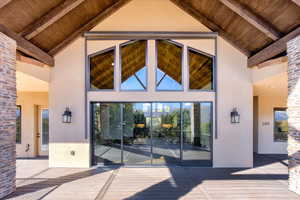 Property entrance with a wooden deck and stucco siding